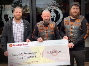 3 men standing behind a large cheque