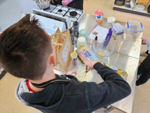 Young boy whisking in kitchen