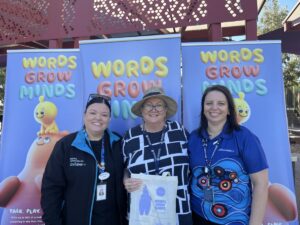 3 women standing in front of blue signs
